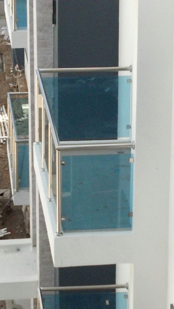 Detalle de baranda de balcón en acero inoxidable y vidrio azul